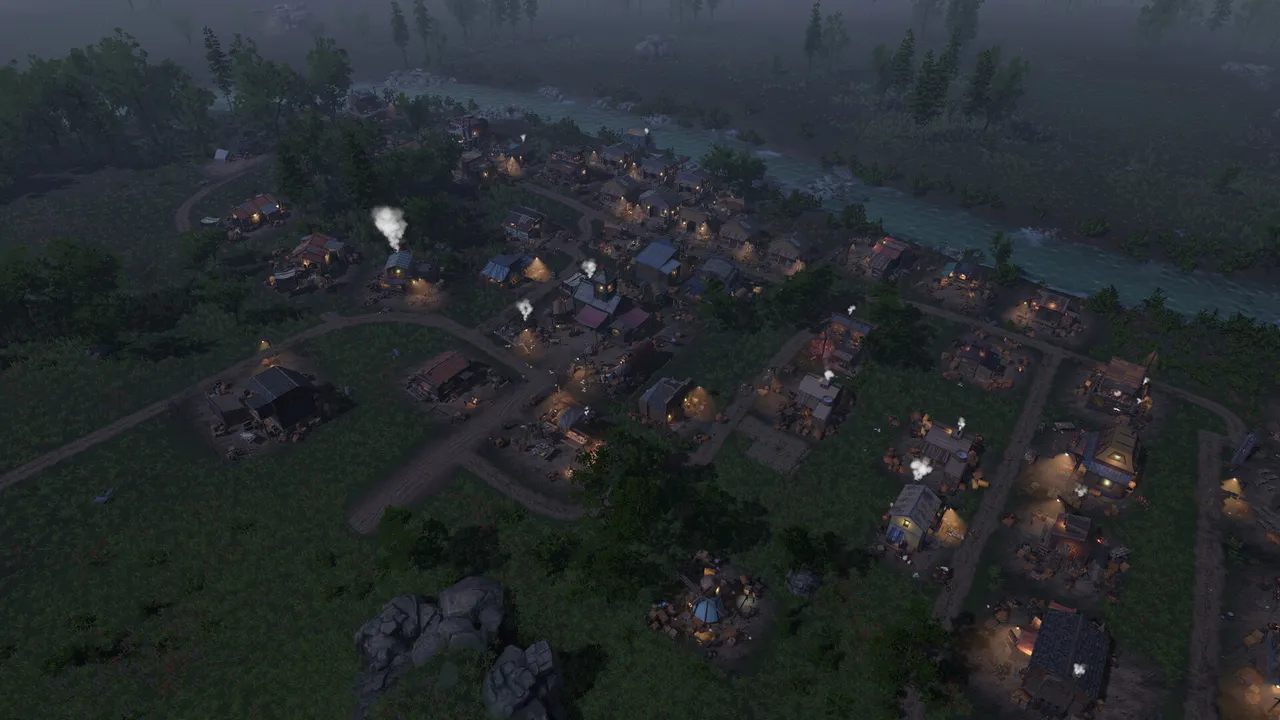 A frontier settlement at night beside a river, with lit windows and smoking chimneys
